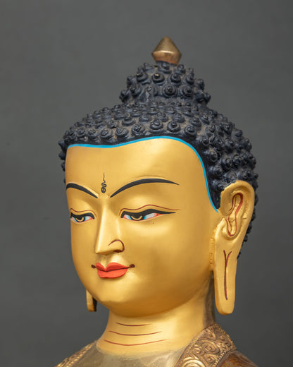 Close up of Shakyamuni Buddha statue with 24K gold painted face.