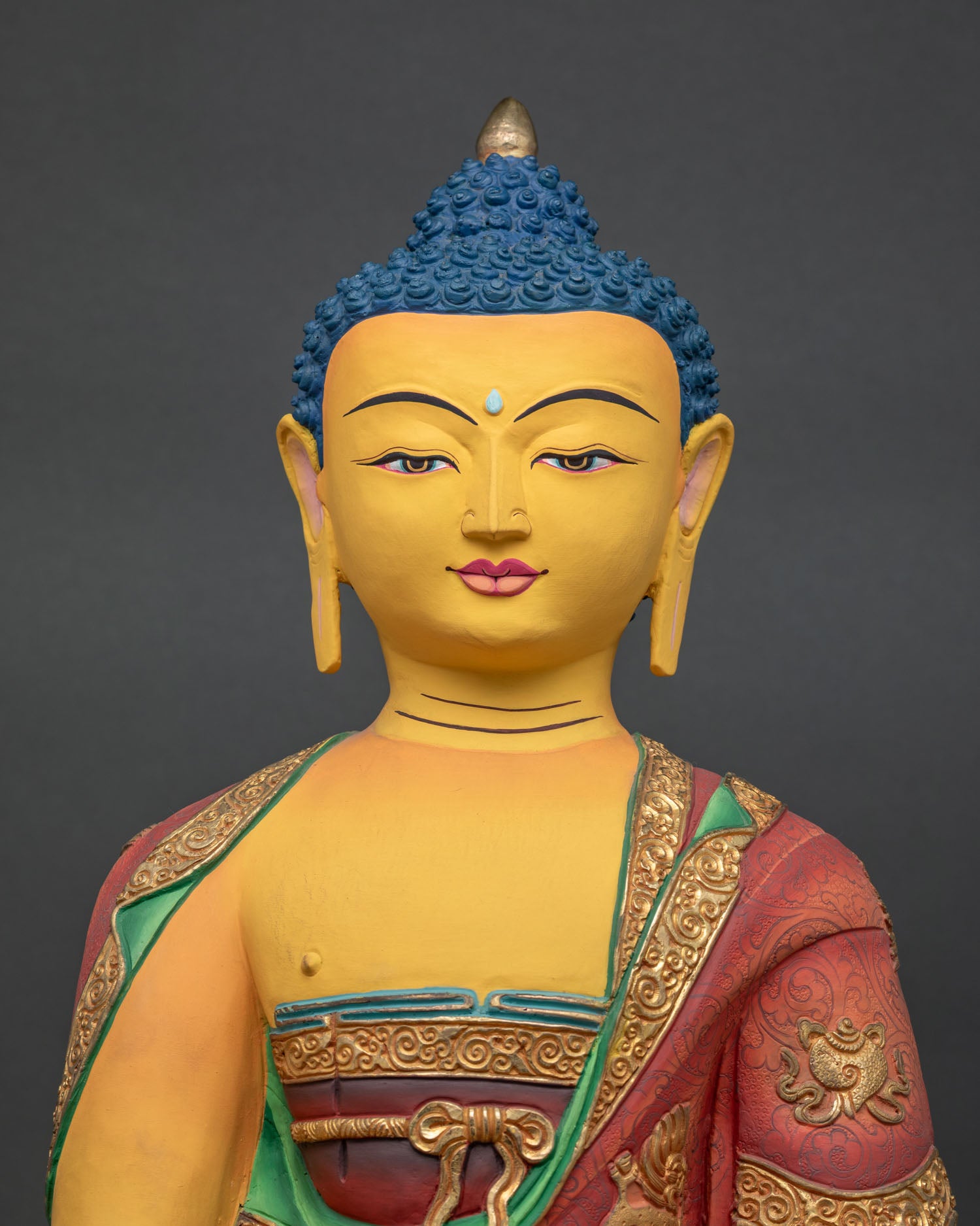 Close up of Shakyamuni Buddha Statue featuring gold painted face and intricate acrylic details