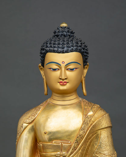 Close-up of Shakyamuni Buddha statue gold-painted face and hand-incised robe detail