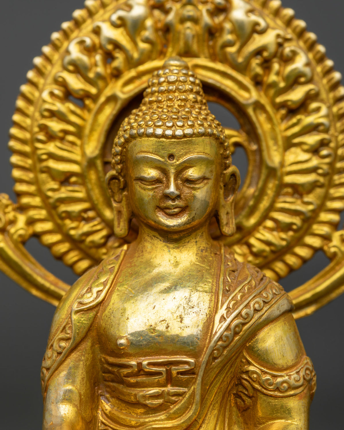Close up of Shakyamuni Buddha statue performing bhumisparsha mudra with serene expression.