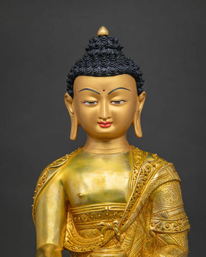 Close-up of Shakyamuni Buddha statue showing gold fire gilding and hand-carved robe details