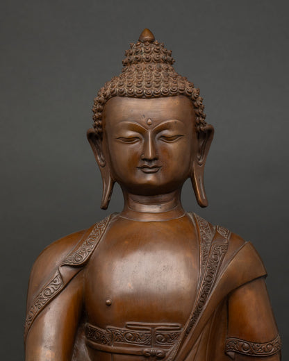 Close-up of Shakyamuni Buddha statue showing oxidized copper detail and lotus pedestal