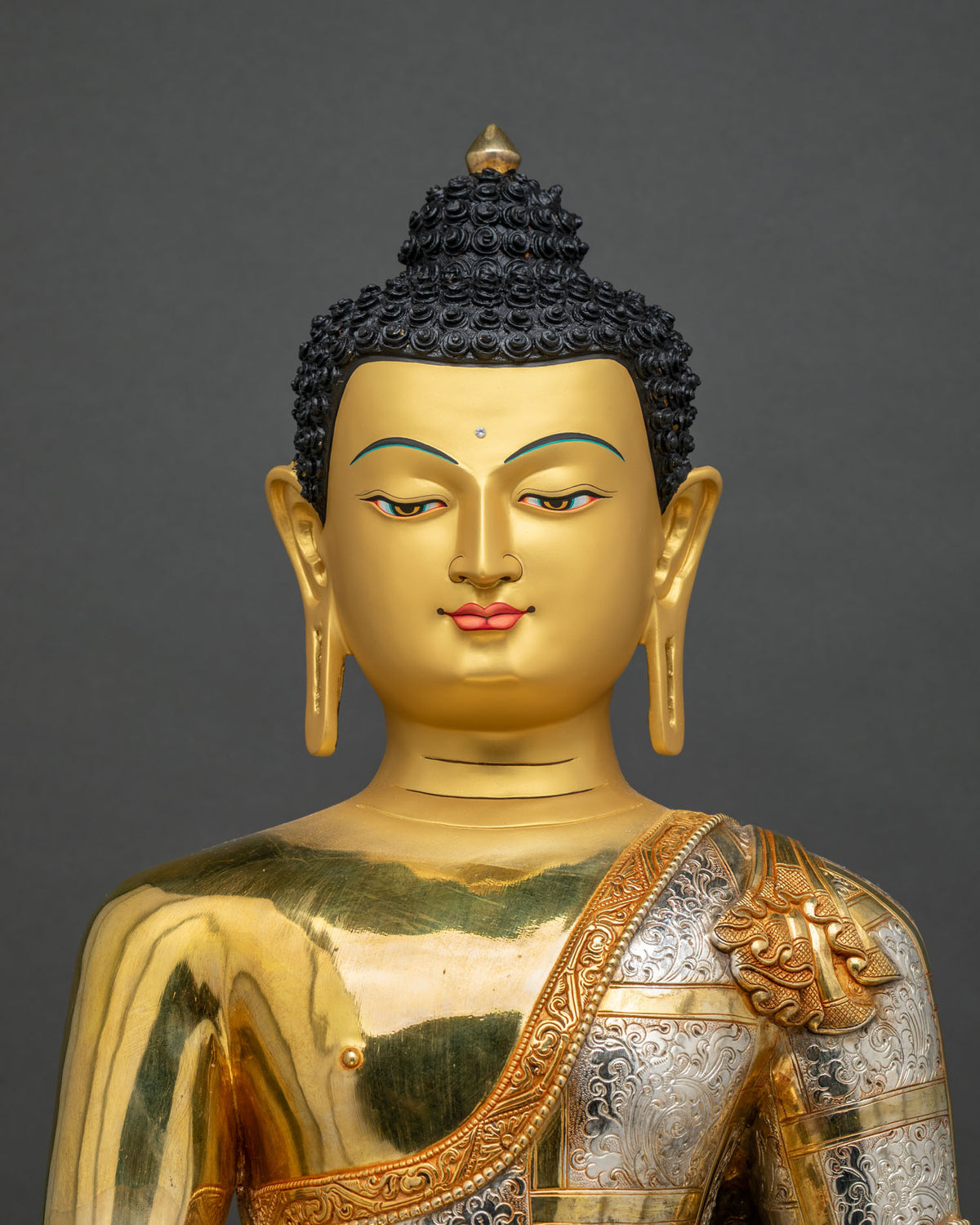 Close up of Shakyamuni Buddha statue torso with gold fire-gilding and silver-plated robe from Nepal