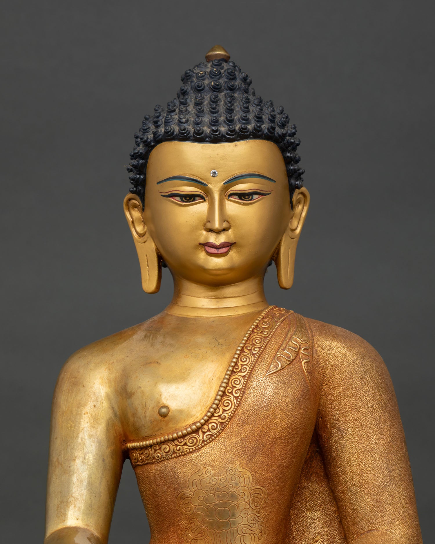 Close-up of Shakyamuni Buddha statue with gold gilding and intricate copper craftsmanship
