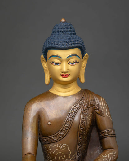 Close up of Shakyamuni Buddha statue with gold-painted face and silver-plated robe scrollwork
