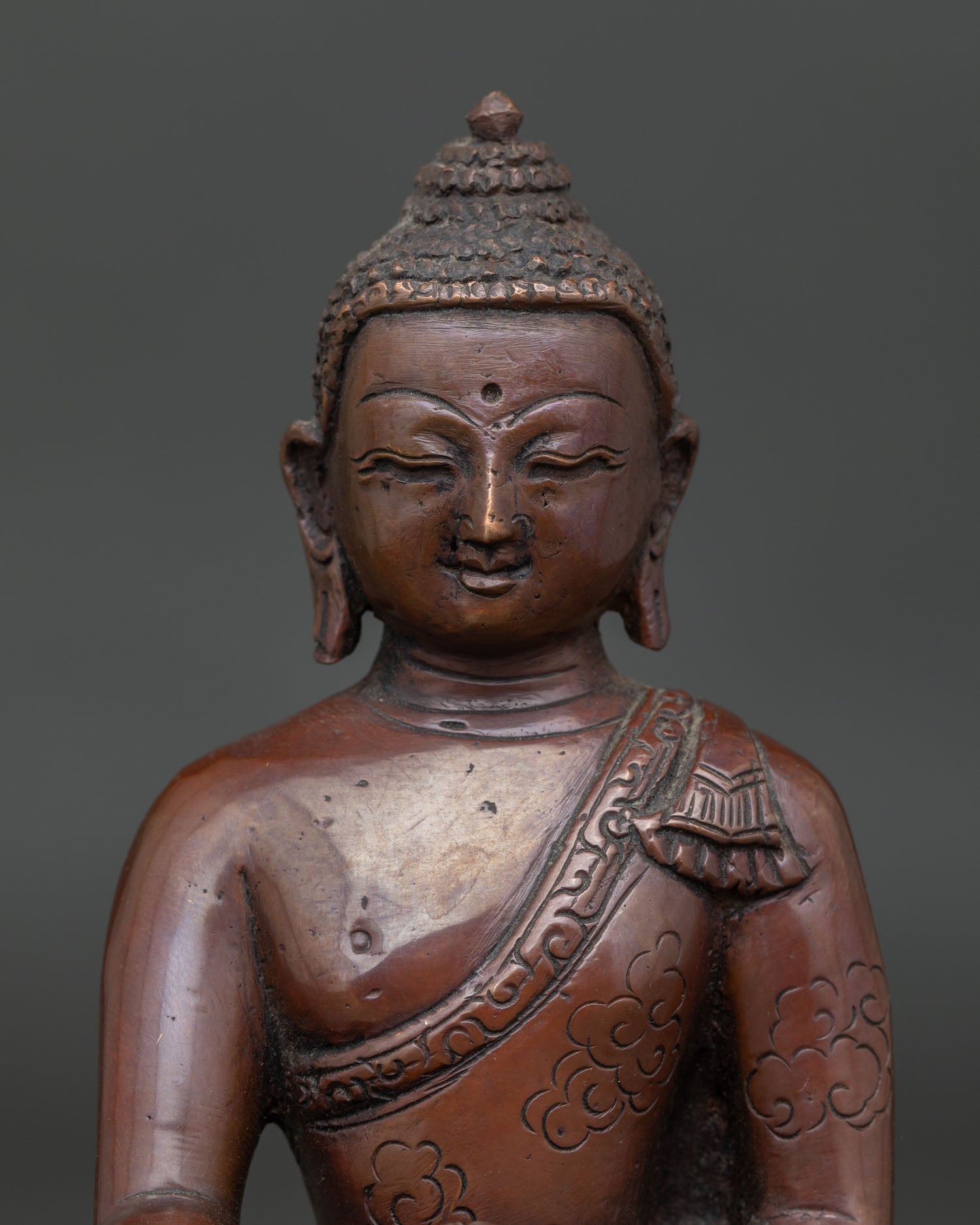 Close-up of Shakyamuni Buddha Statue with serene face Earth Touching Mudra and Patra bowl.