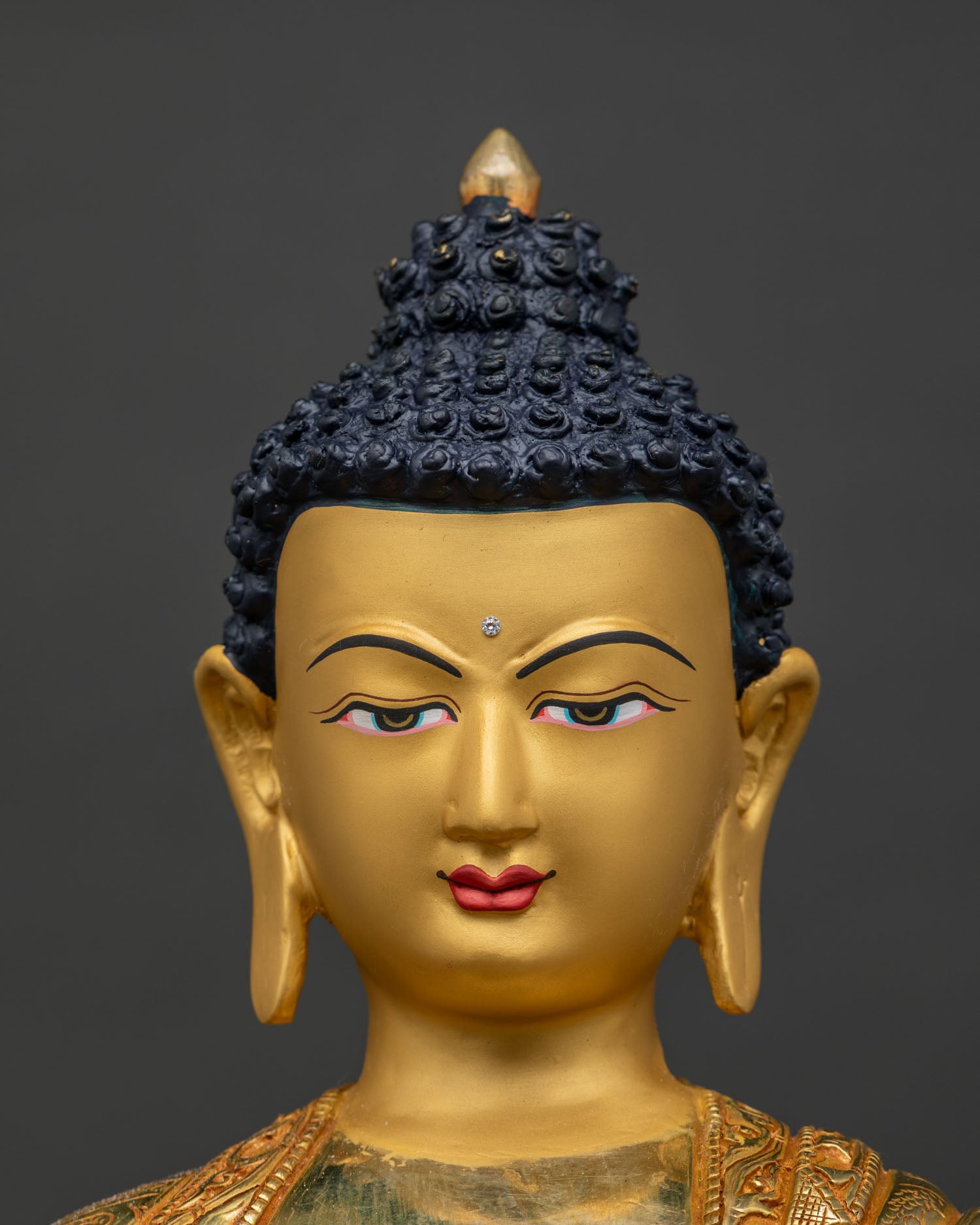 Close-up of Shakyamuni Buddha statue's gold-painted face detail