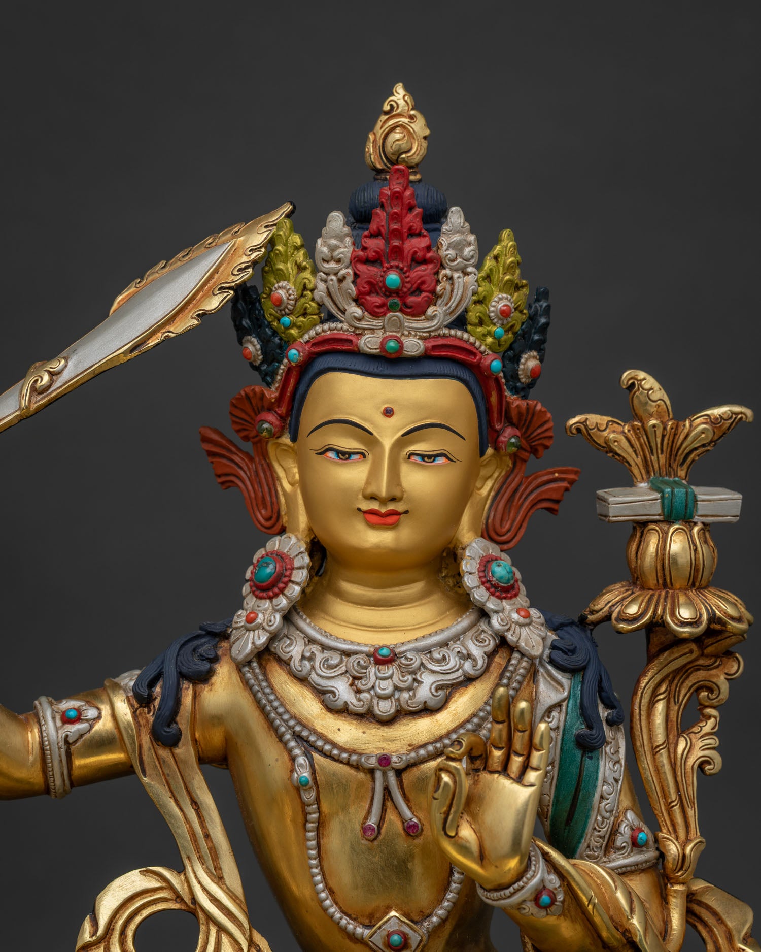 Close-up of Simhanada Manjushri statue showing gold gilding and sacred ornaments