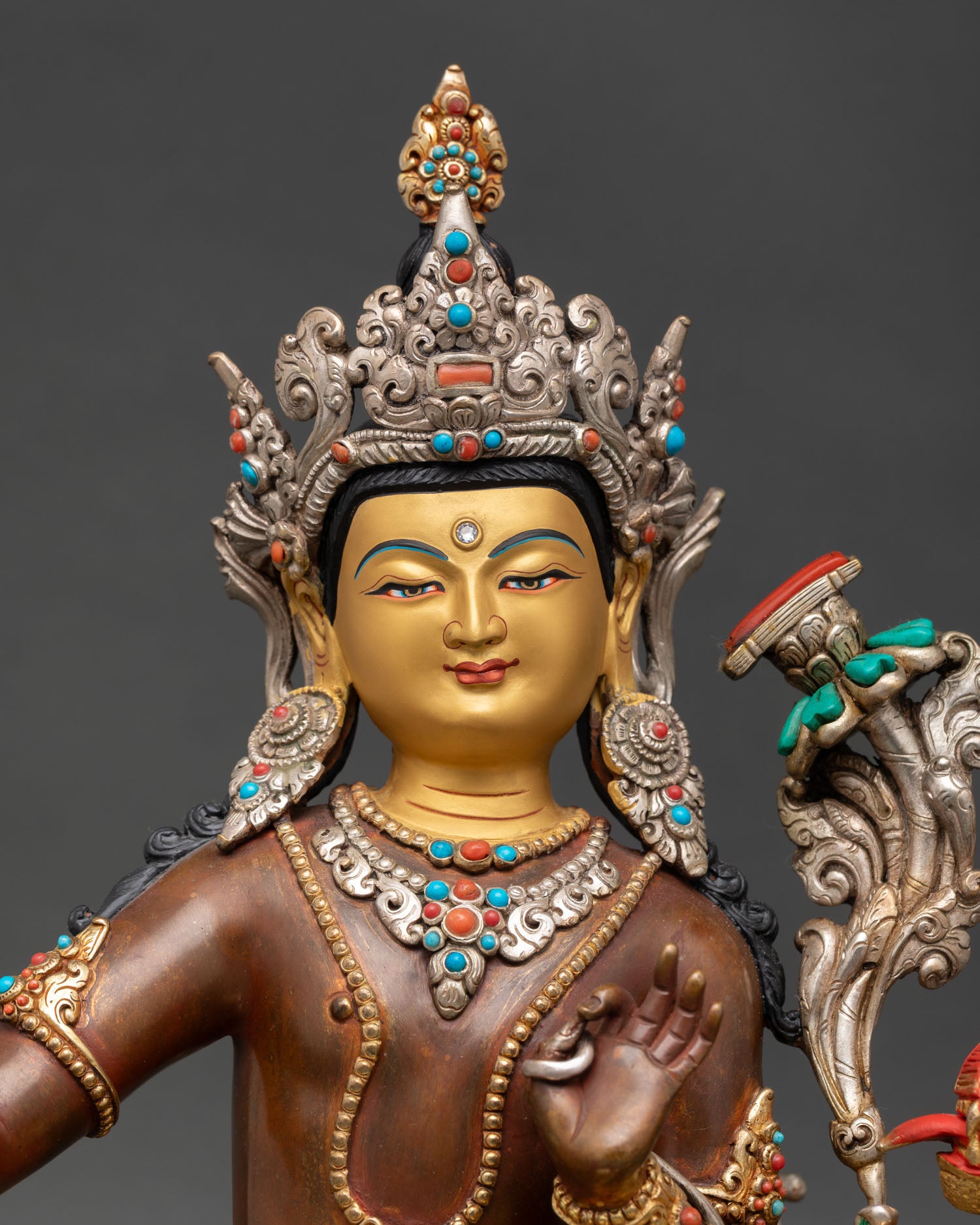 close up of simhanada manjushri statue with gold gilded robe and lion throne