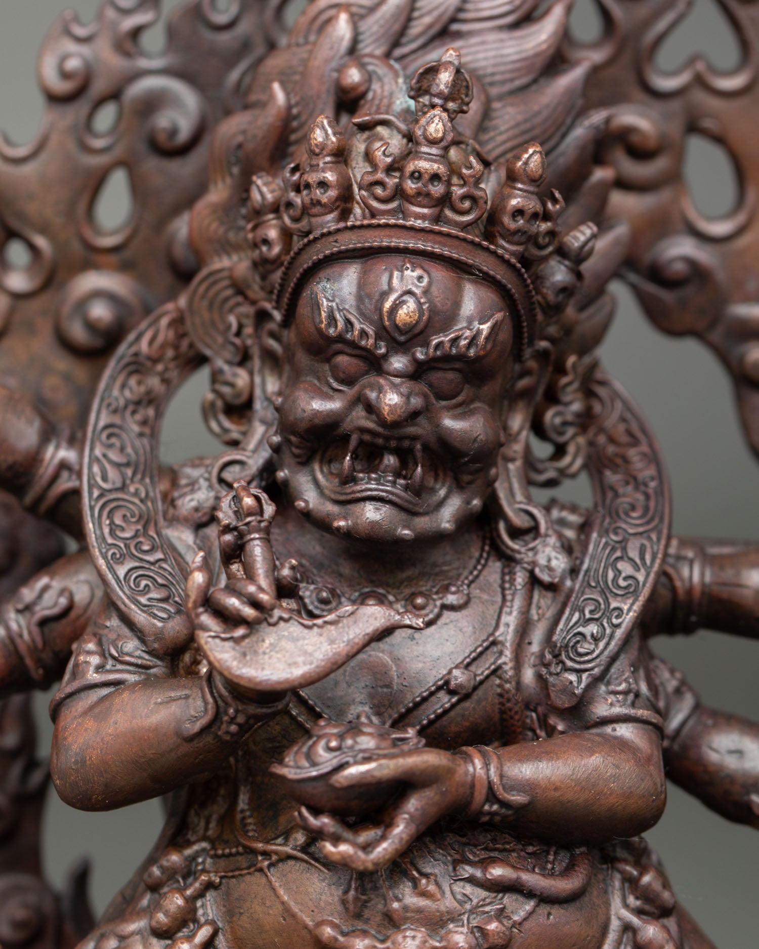 Close up of Six Armed Mahakala gold painted face with third eye and fierce expression
