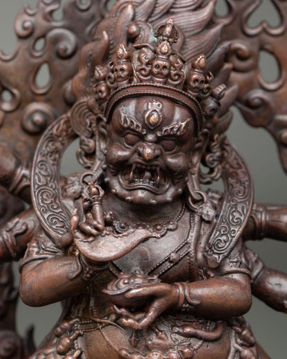 Close up of Six Armed Mahakala gold painted face with third eye and fierce expression