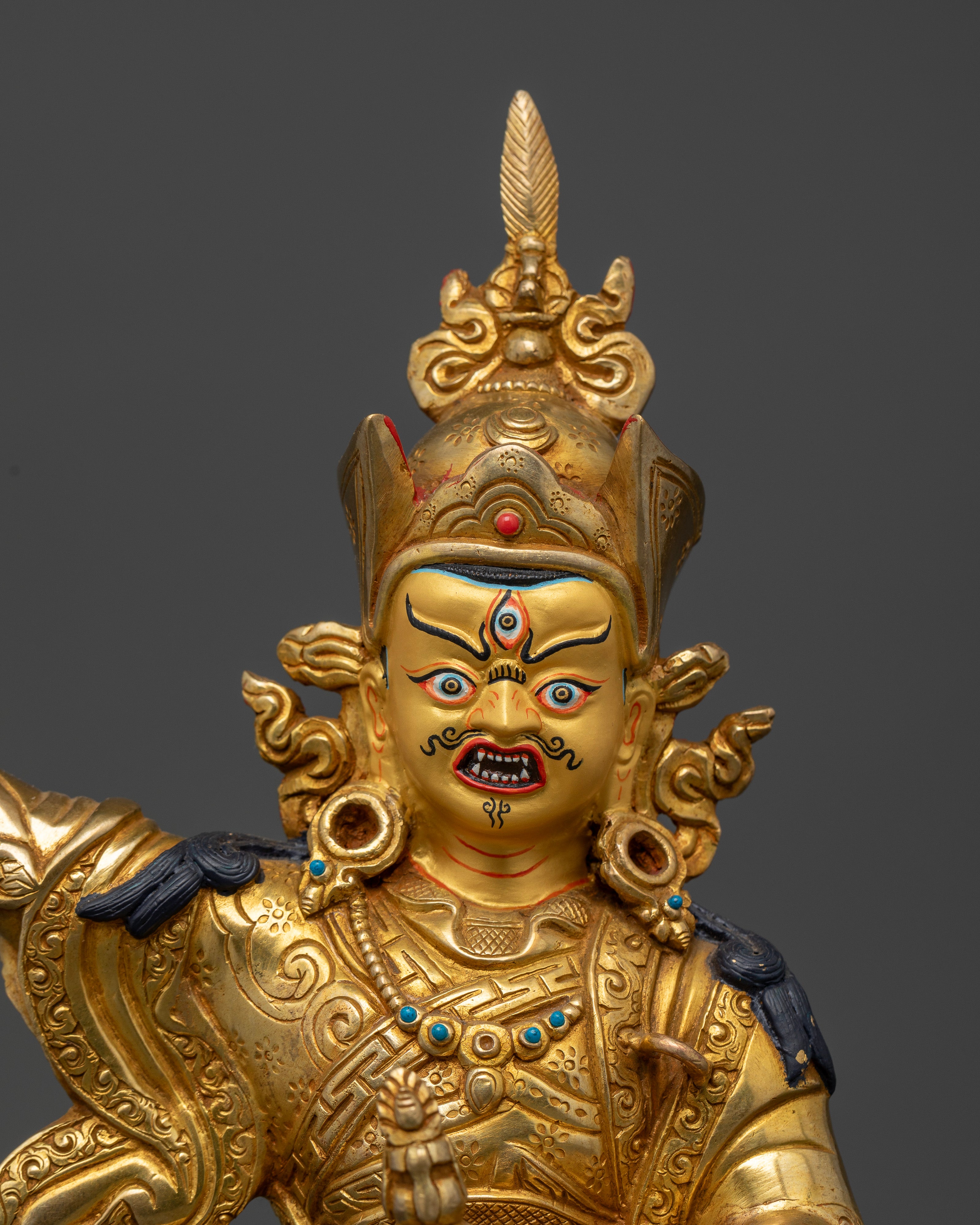 Close up of Standing Padmasambhava Statue with gold painted face and sacred details