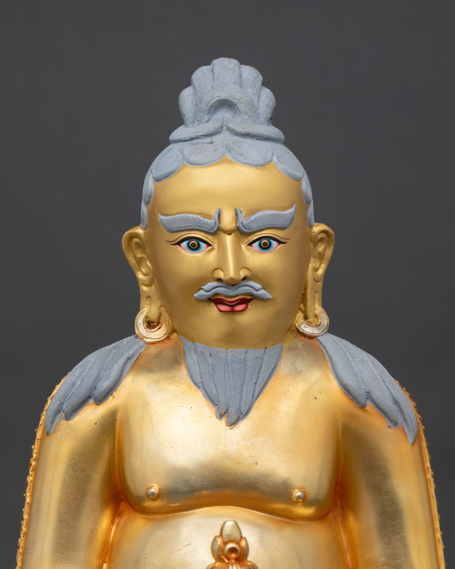 close up of thangtong gyalpo statue showing gold gilded details and lotus throne