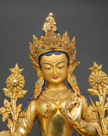 Close-up of the Green Tara face, jeweled crown and lotus stems on a handcrafted gold gilded statue
