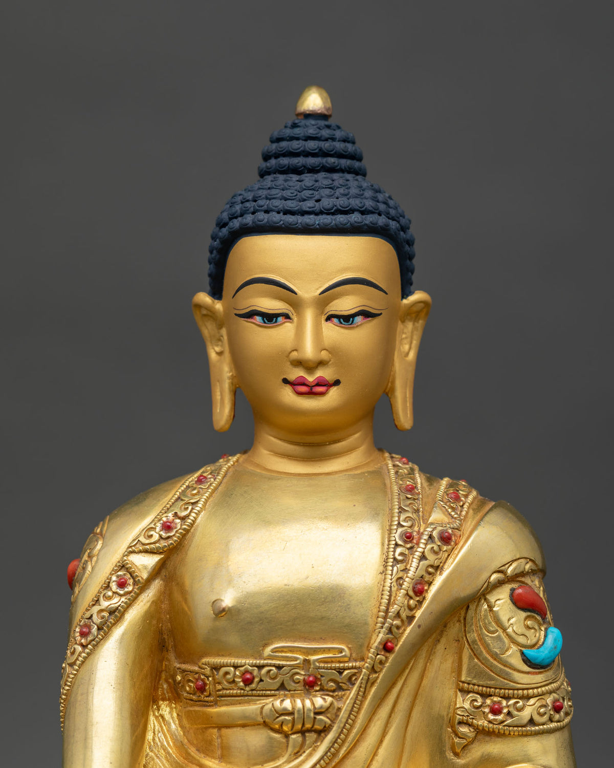 Close up of the handcrafted copper Shakyamuni Buddha idol showing intricate floral robe details.
