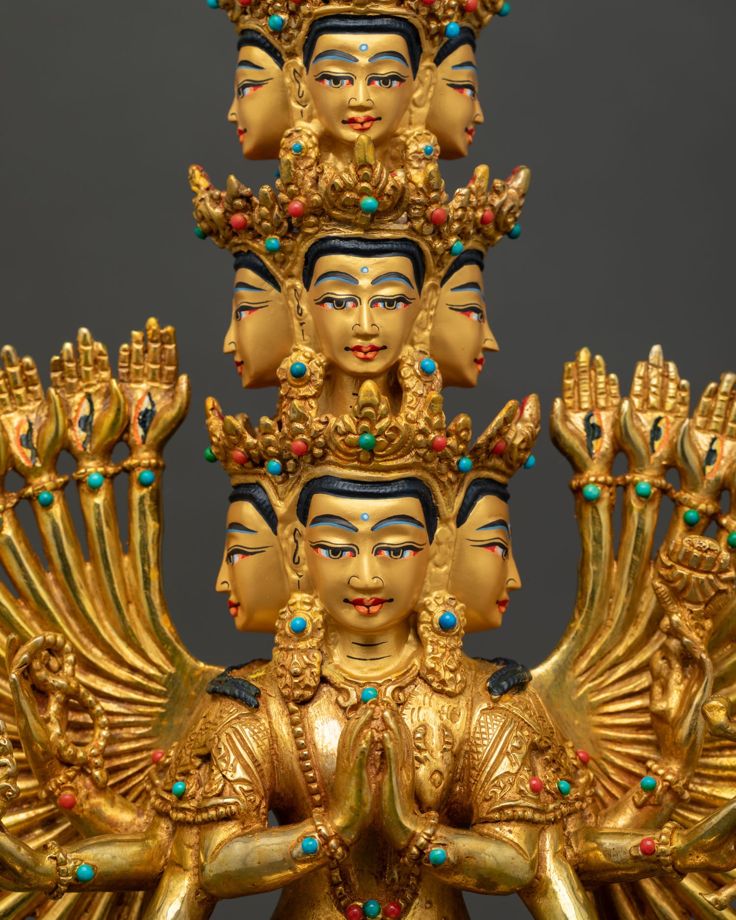 Close-up of Thousand-Armed Chenrezig statue with gold gilding and sacred Buddhist details