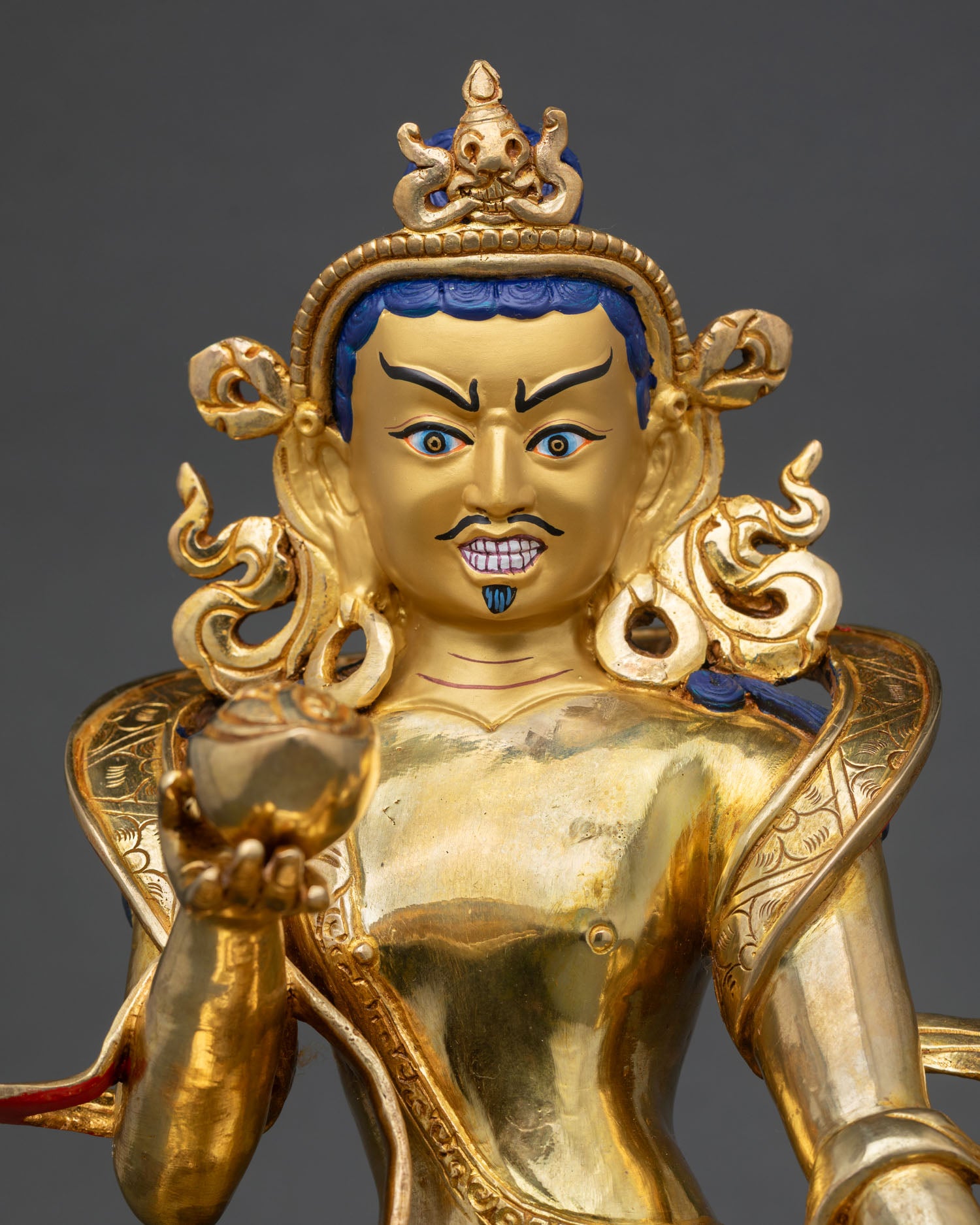 close up of tilopa buddhist statue showing intricate copper carving and sacred details