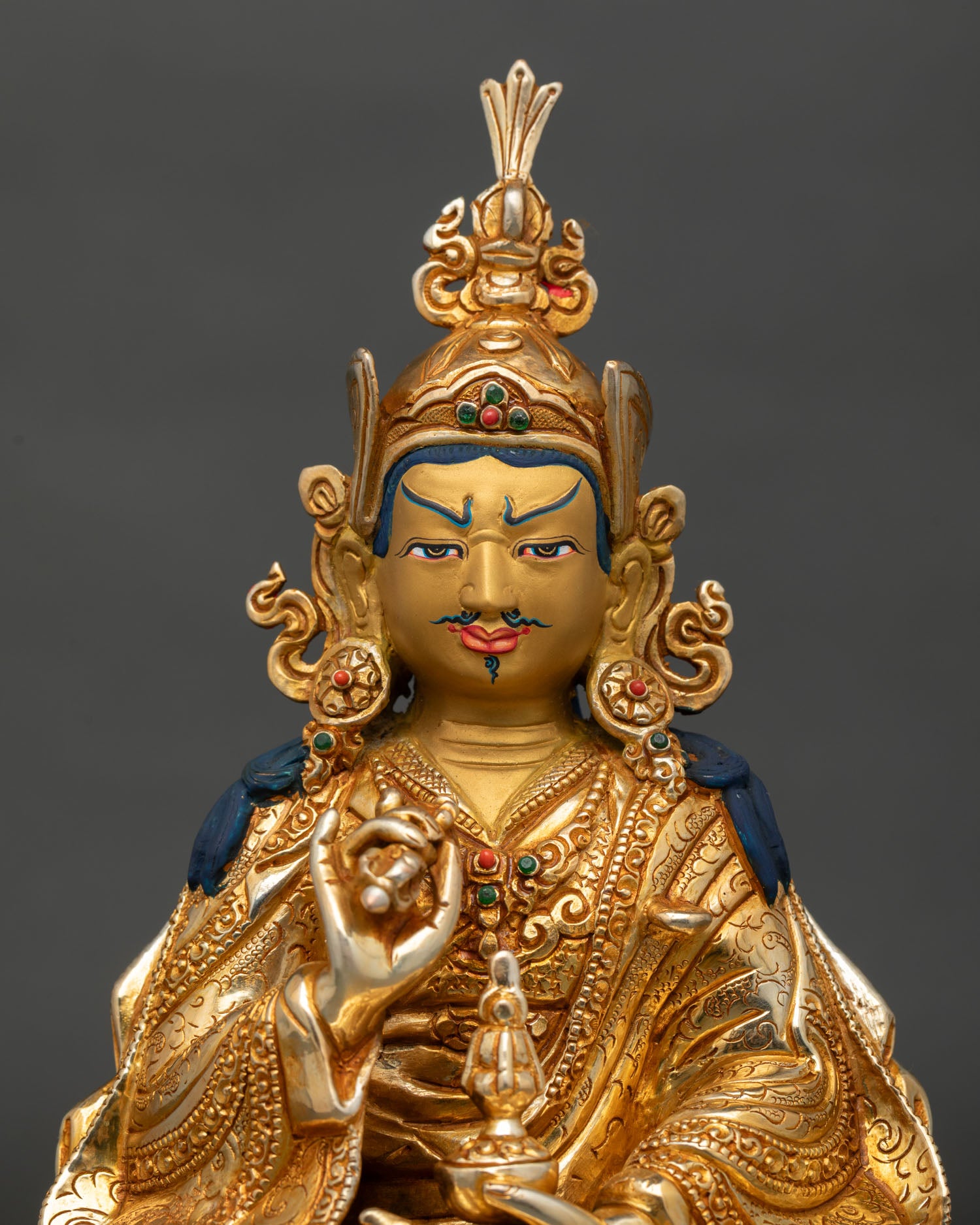 Close up of Tsokye Dorje statue showing gold painted face floral motifs and semi precious stones