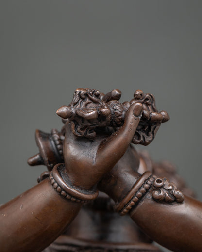 Close-up of Vajradaka’s hands holding a ritual vajra at the chest