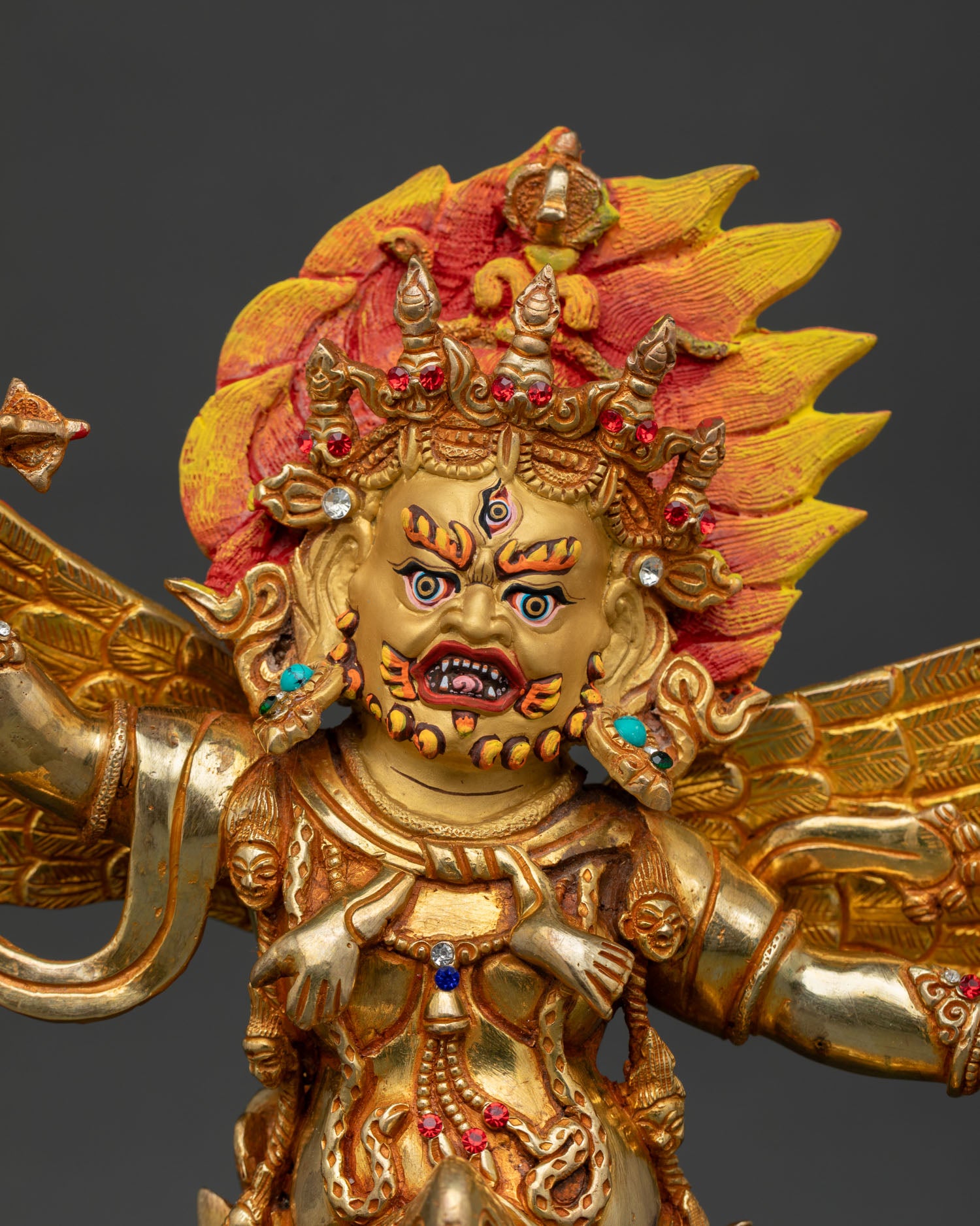 Close up of Vajrakilaya statue with gold painted face and wrathful expression