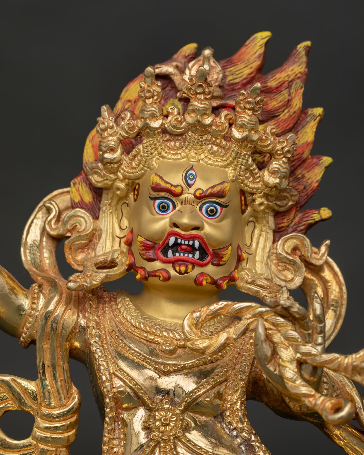 Close Up of Vajrapani Statue with Gold Painted Face and Powerful Wrathful Expression in Himalayan Buddhist Style