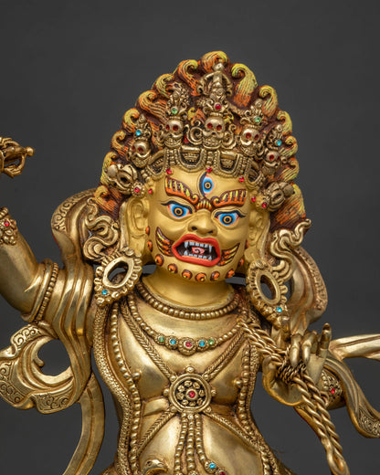 Close up of Vajrapani statue with 24K gold gilding, five-skull crown and lasso detail