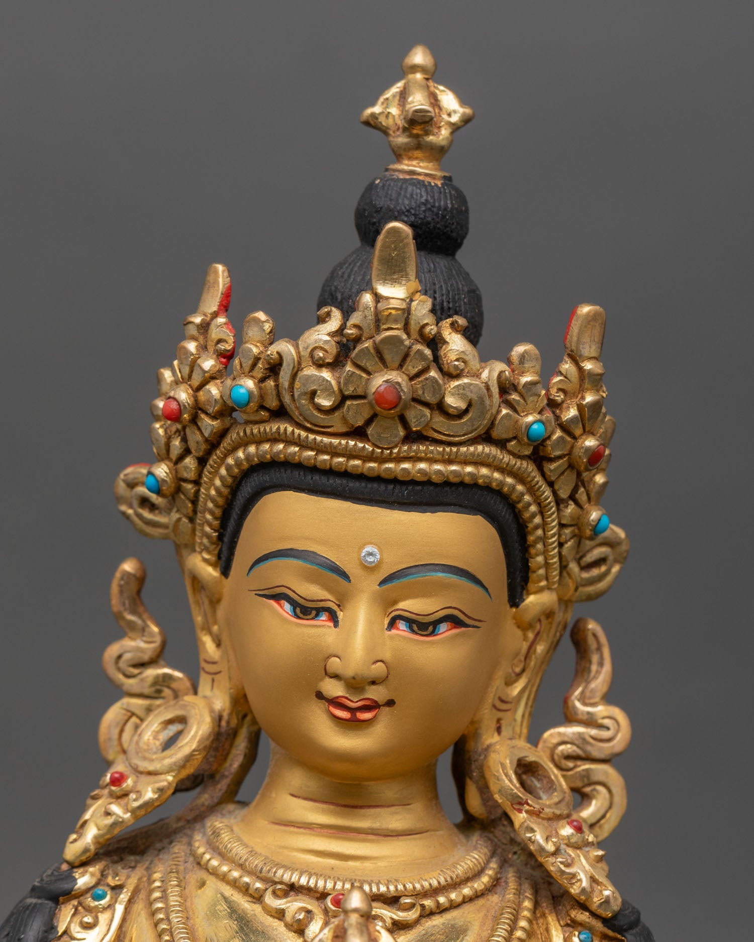 Close up of Vajrasattva gold-painted face, flaming aureole and jeweled crown