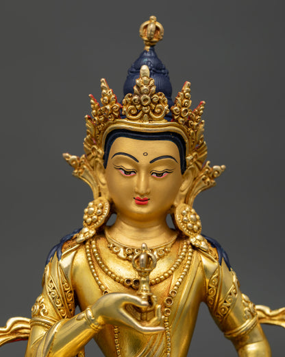 Close-up of Vajrasattva statue gold-painted face holding vajra details