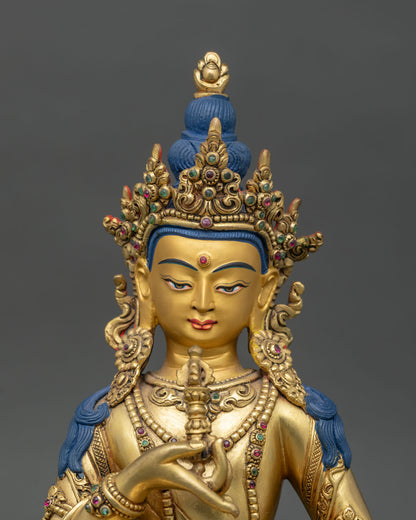Close-up of Vajrasattva statue showing copper body, gemstones, and detailed gilding