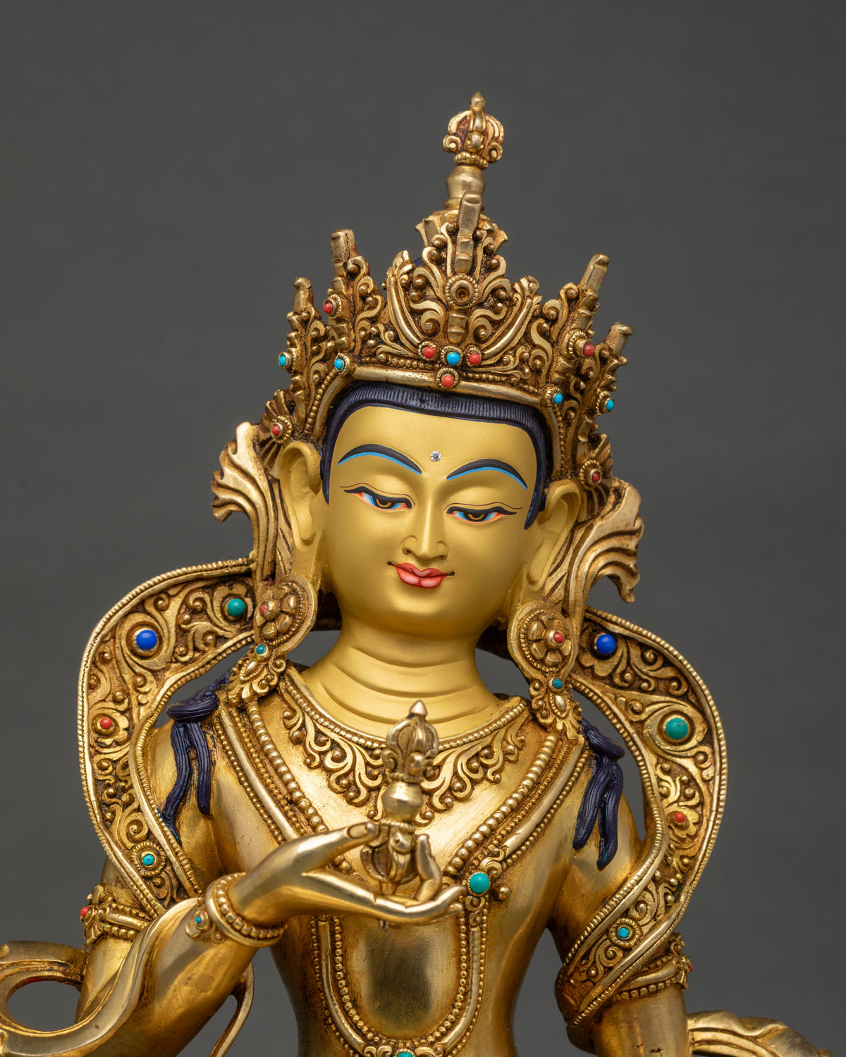 Close up of Vajrasattva statue showing gold gilding and crown detail