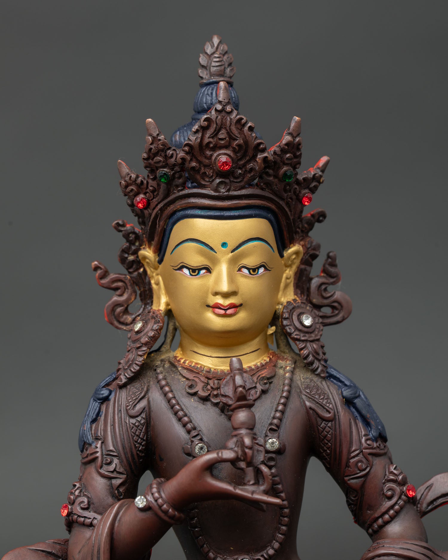 Close Up of Vajrasattva Statue with Semi Precious Stones and Serene Gold Painted Face.