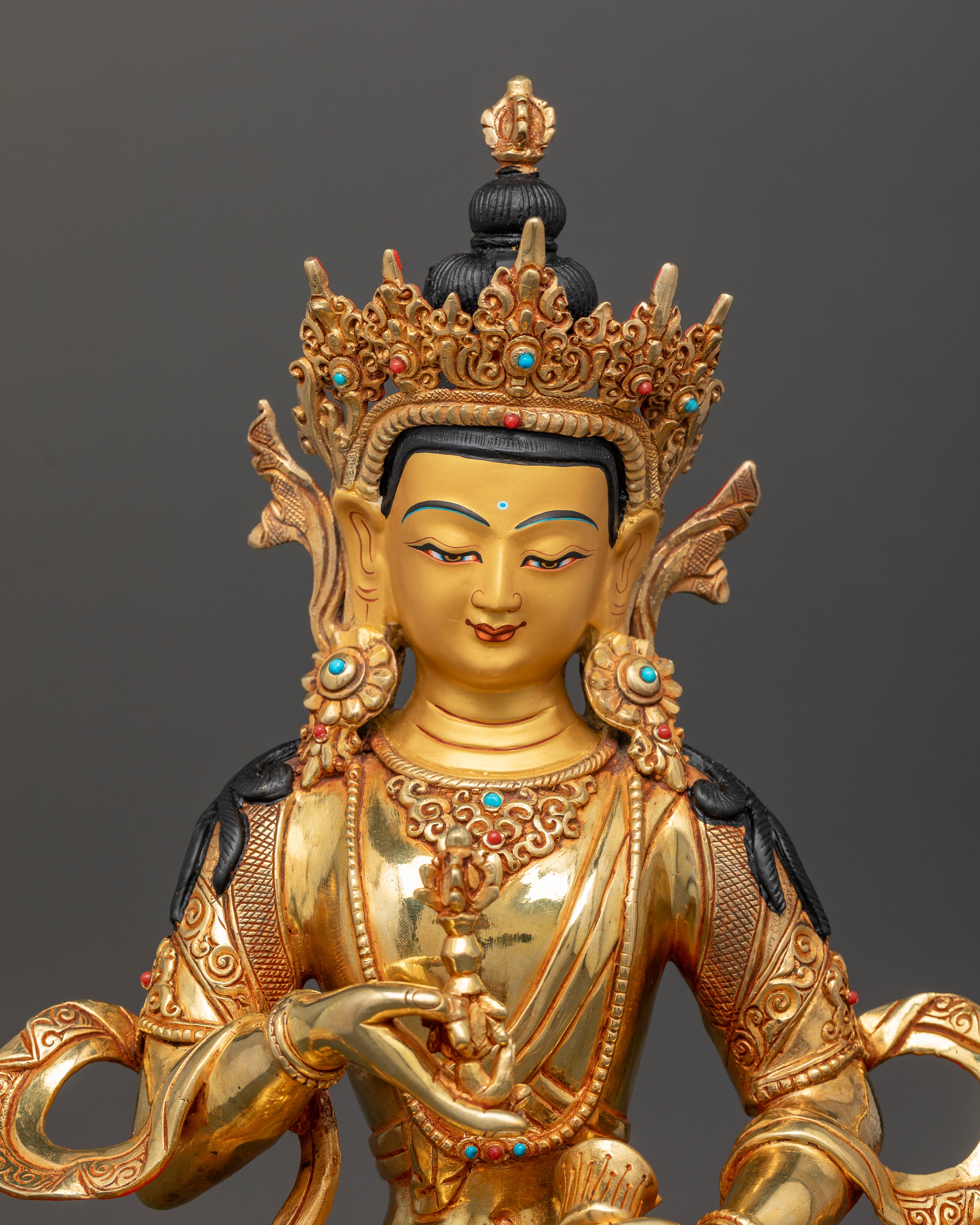 Close up of Vajrasattva statue with vajra bell and semi precious stone details
