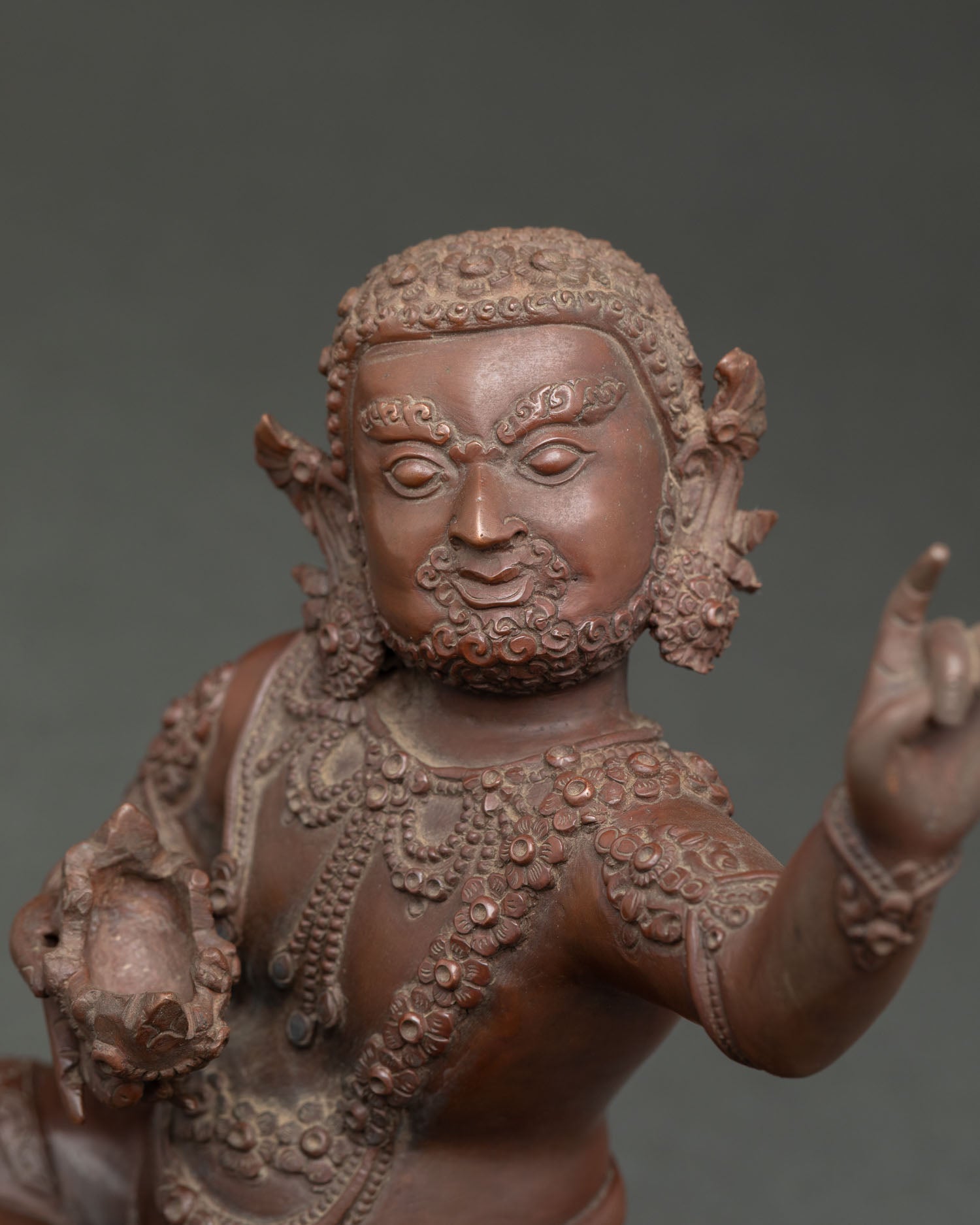 Close up of Virupa statue showing intricate jewelry lotus seat and skull cup symbolism