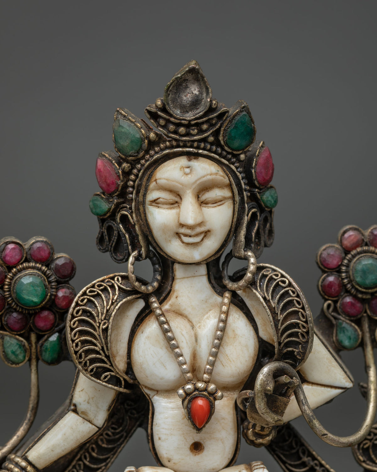 Close up of White Tara face and jeweled crown on handmade Buddhist mini statue