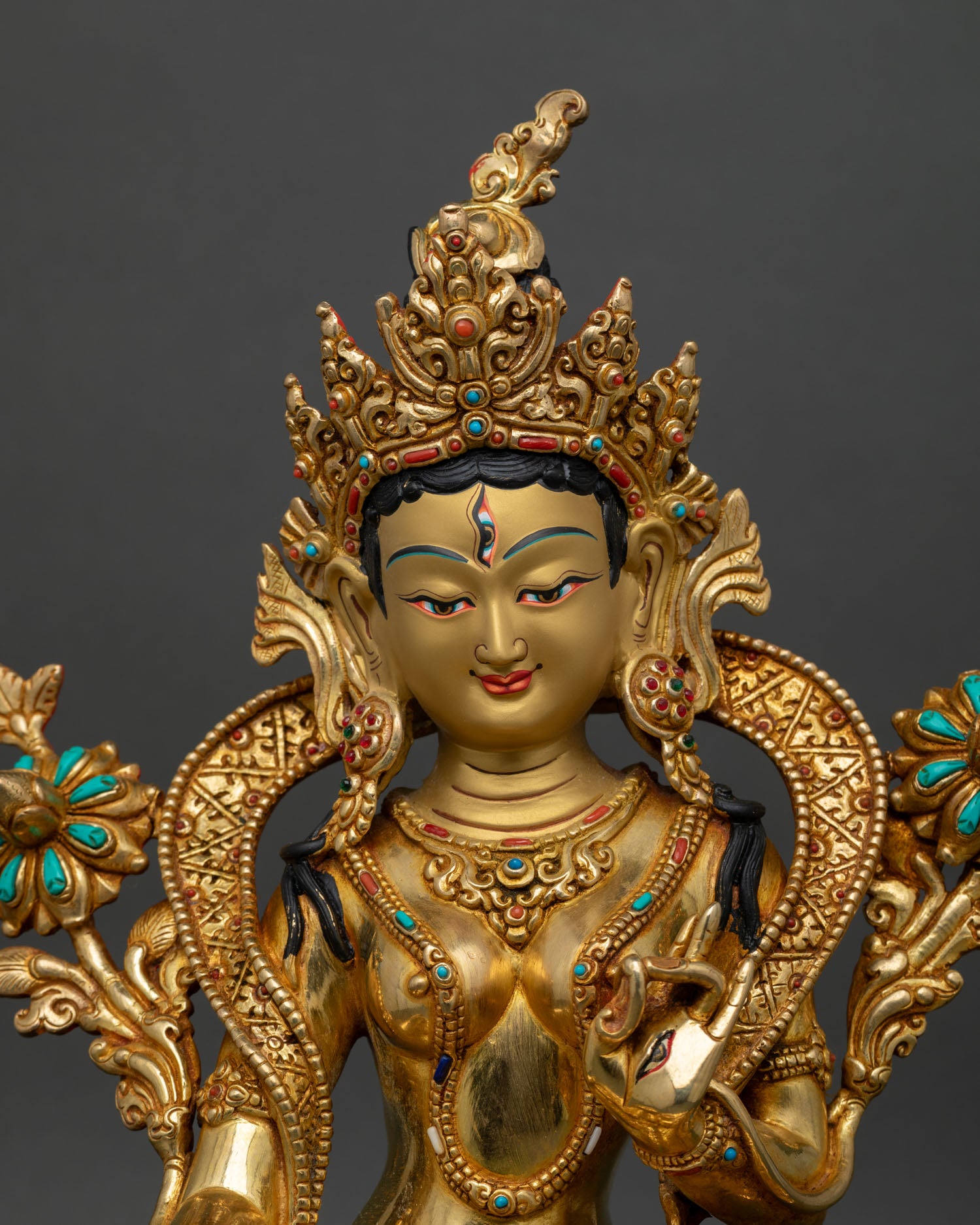 Close up of white tara face gold painted hand set semi precious stones patan nepal