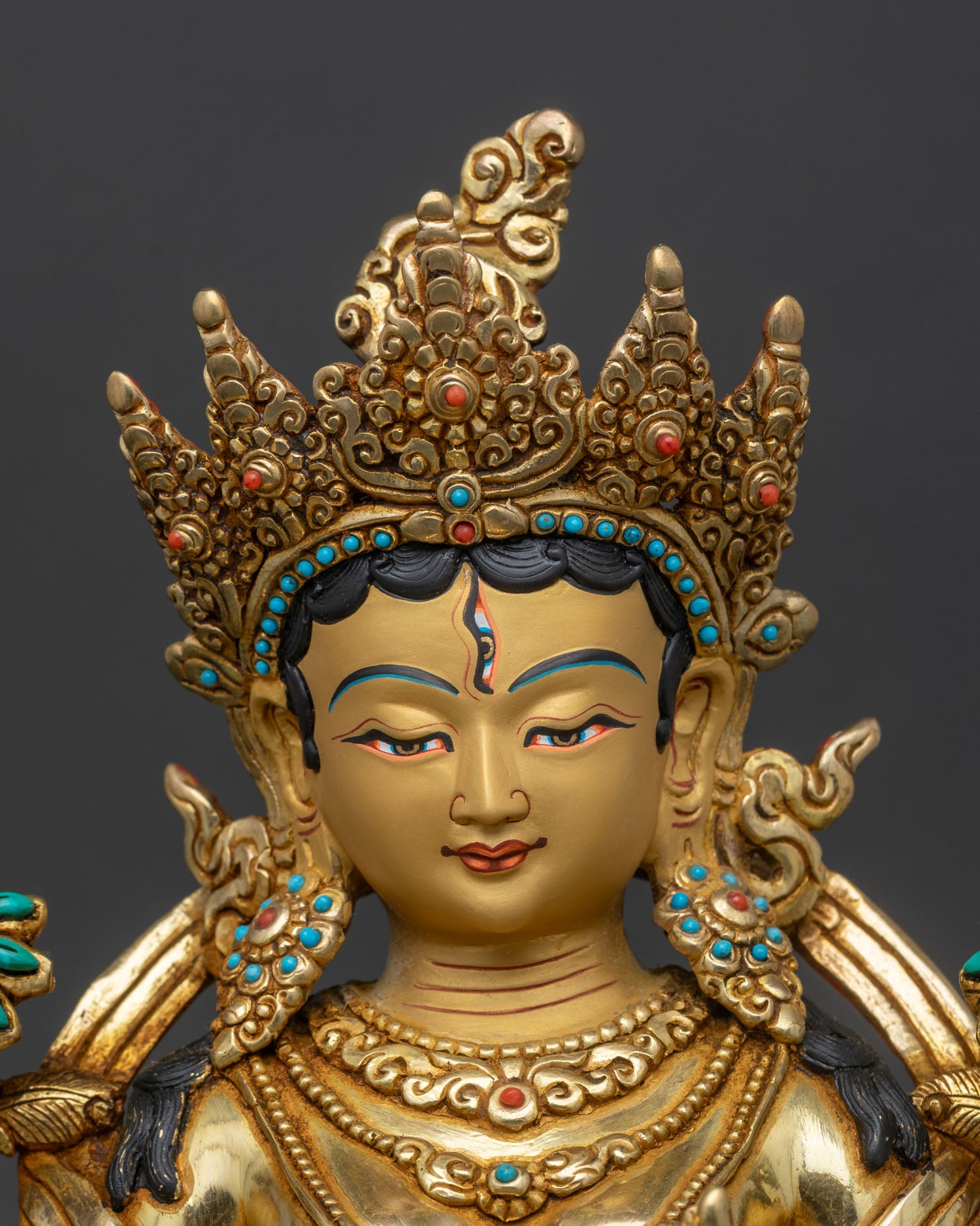 Close up of White Tara face with seven eyes gold painted and hand set semi precious stones