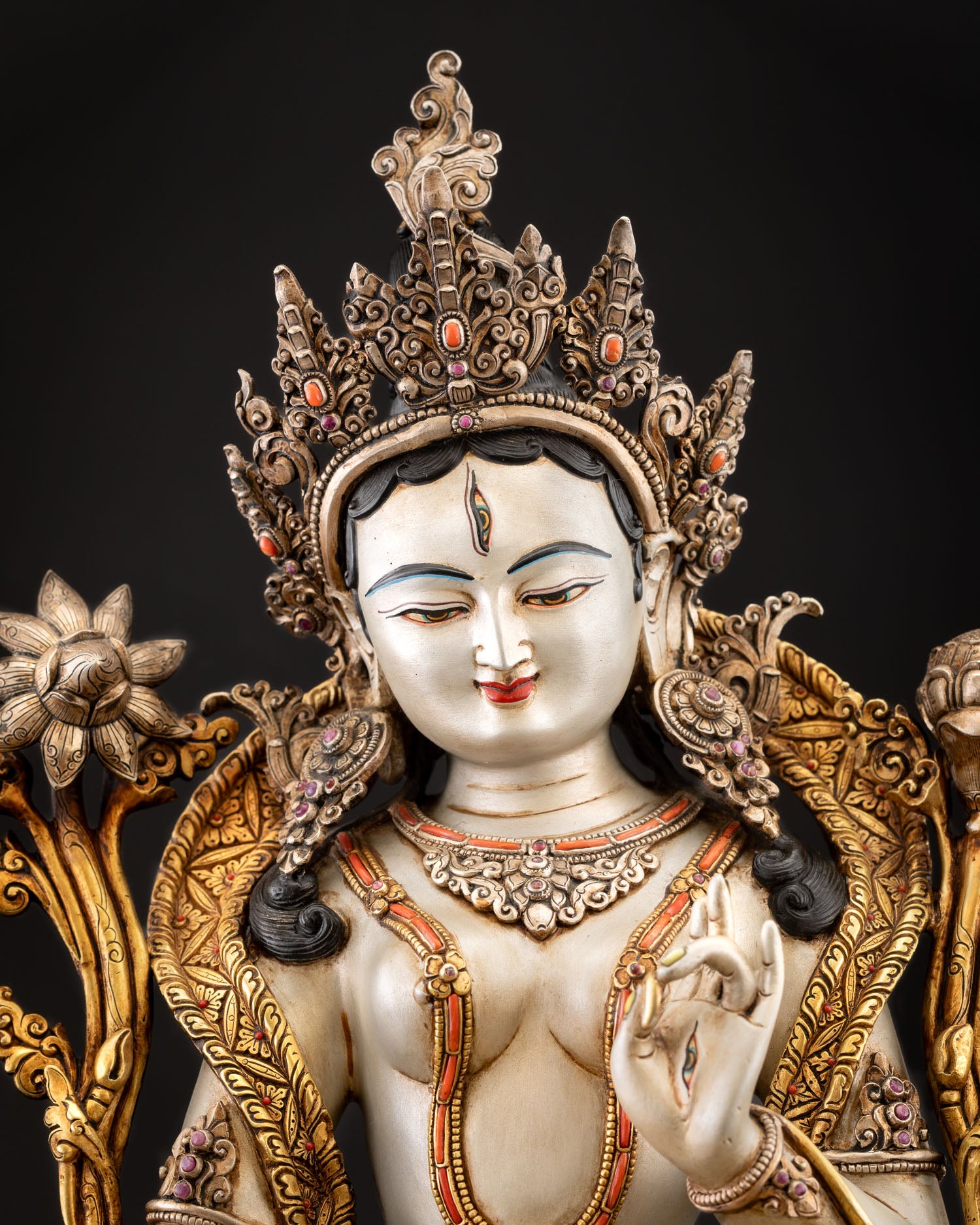 Close up of White Tara face with seven eyes white body and five jeweled crown detailing