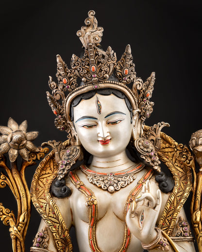 Close up of White Tara face with seven eyes white body and five jeweled crown detailing
