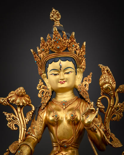 Close-up of White Tara statue face, ornate crown and turquoise-accented gold Buddhist art