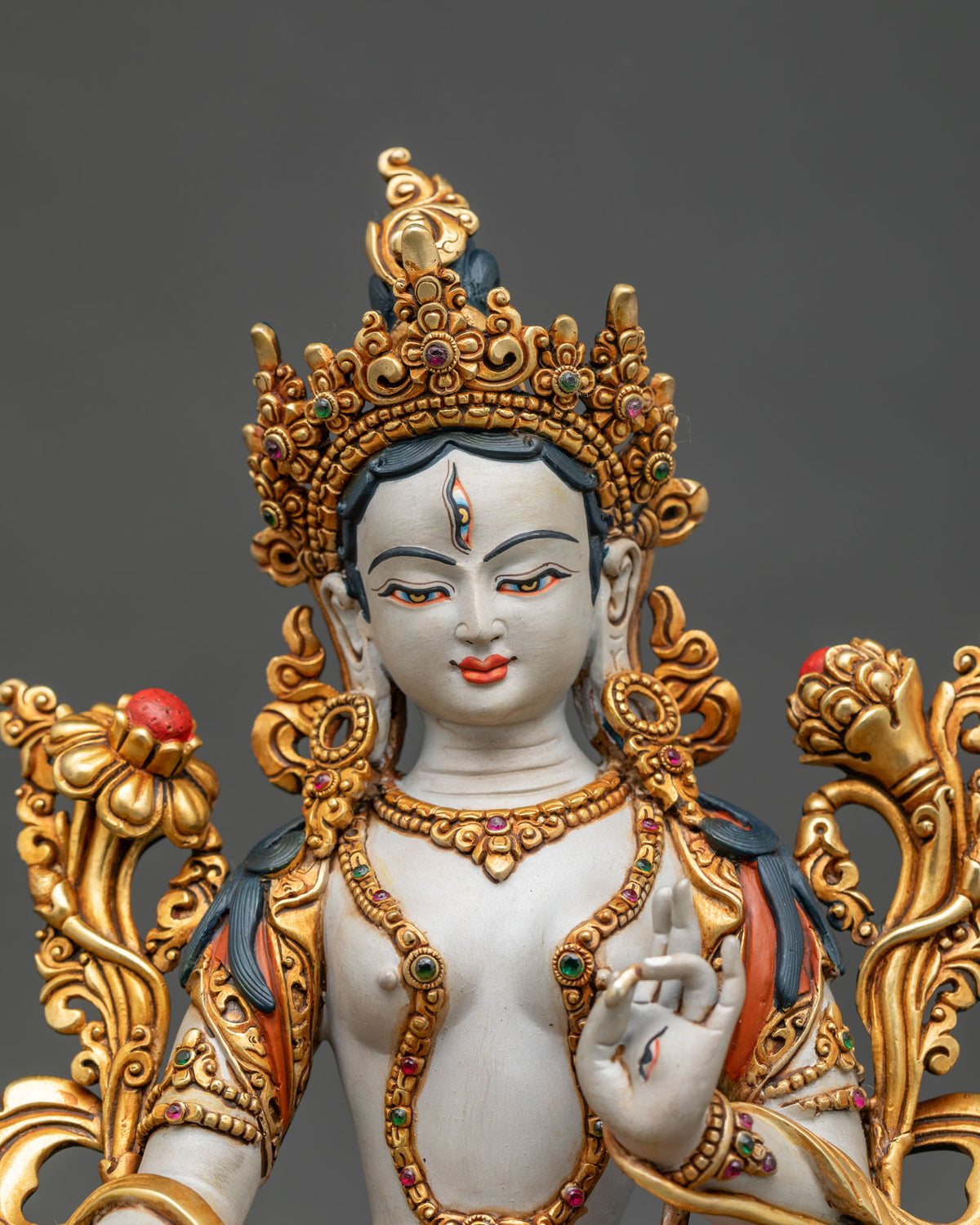 close up of white tara statue seated on lotus with hand chased gold gilded jewelry