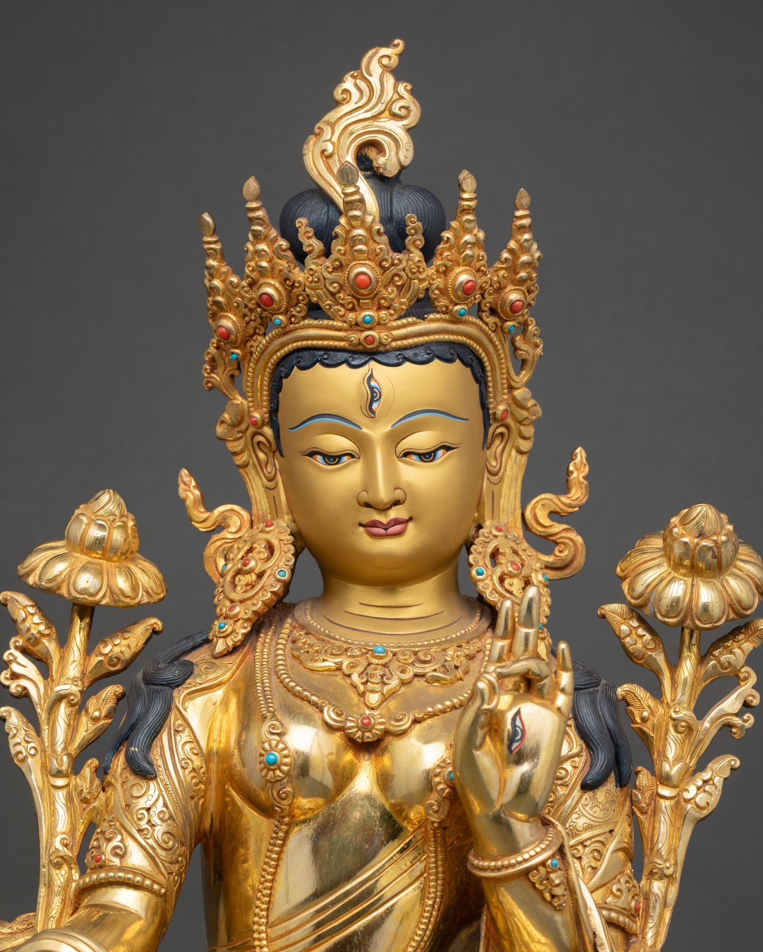 close-up of white tara statue with gold fire gilding and intricate lotus detailing