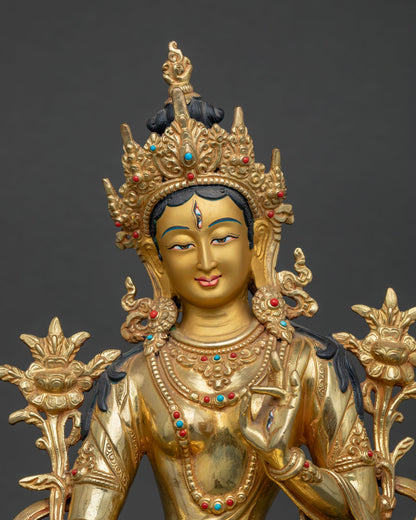 Close up of White Tara Statue with jeweled crown elegant ornaments and serene expression.