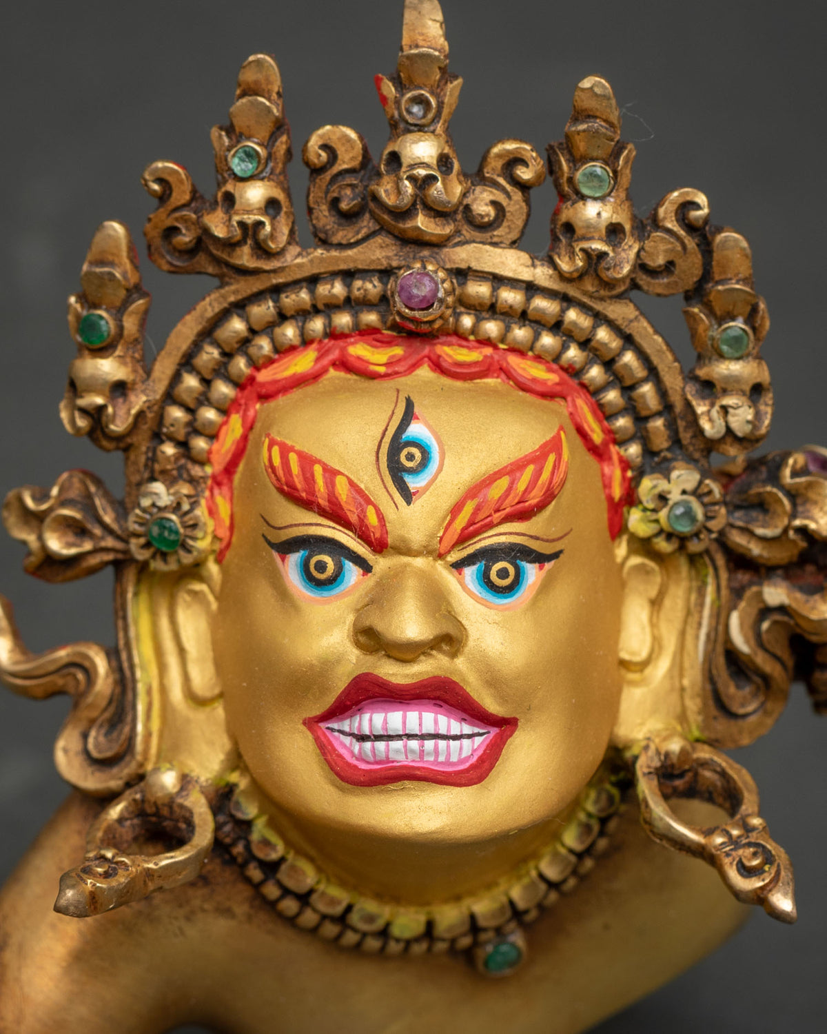 Close-up of wrathful Hevajra face with third eye, flaming eyebrows and jeweled skull crown