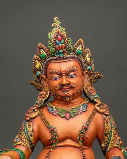 Close up of Yellow Dzambhala statue showing gold gilded crown, jewelry and hand-painted details