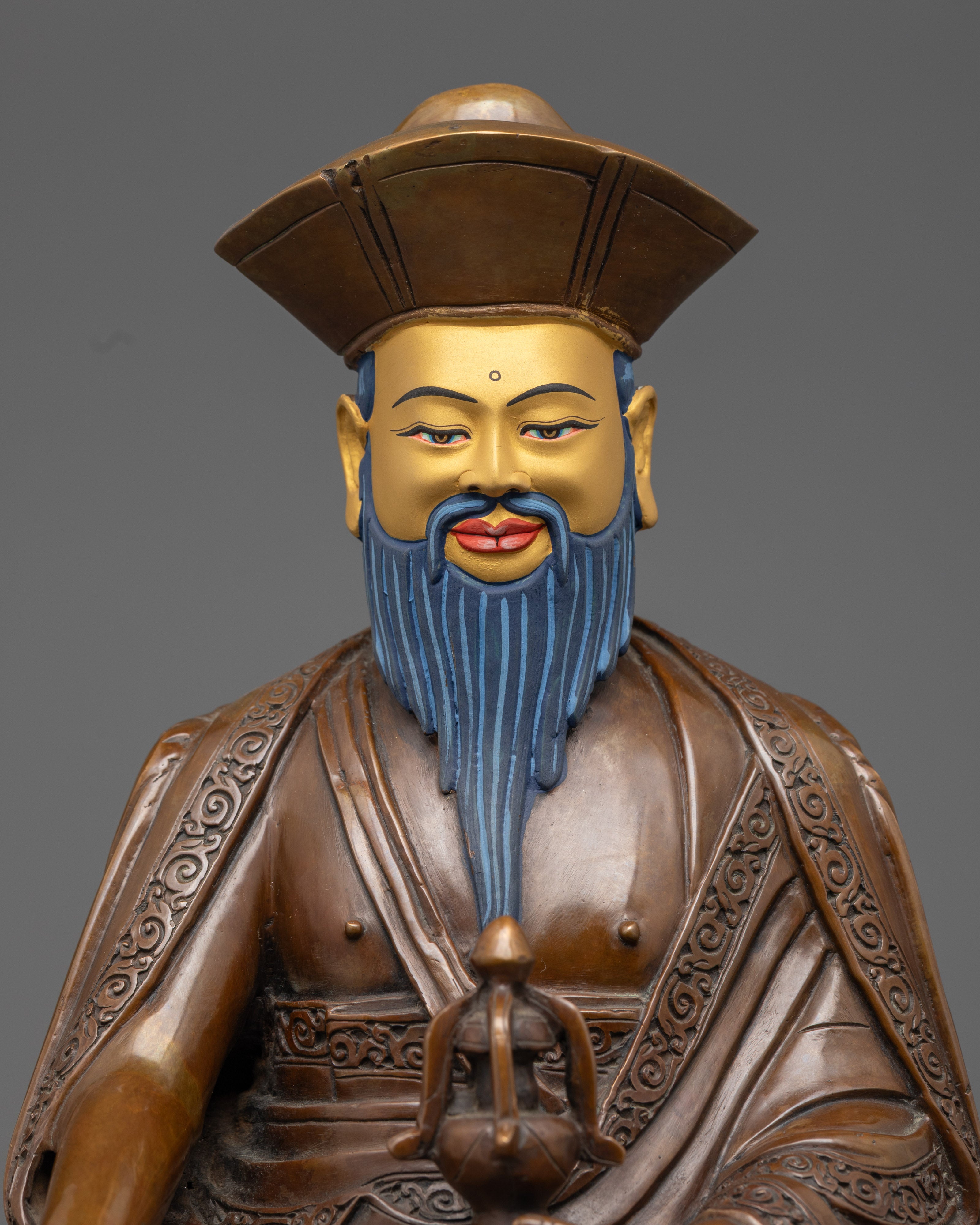 close up of zhabdrung rinpoche statue showing oxidized copper and acrylic detailing