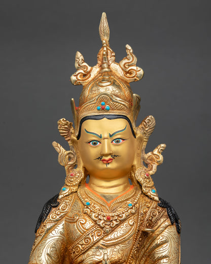 Close up Padmasambhava Guru Rinpoche statue gold painted face semi precious stones intricate Himalayan craftsmanship details