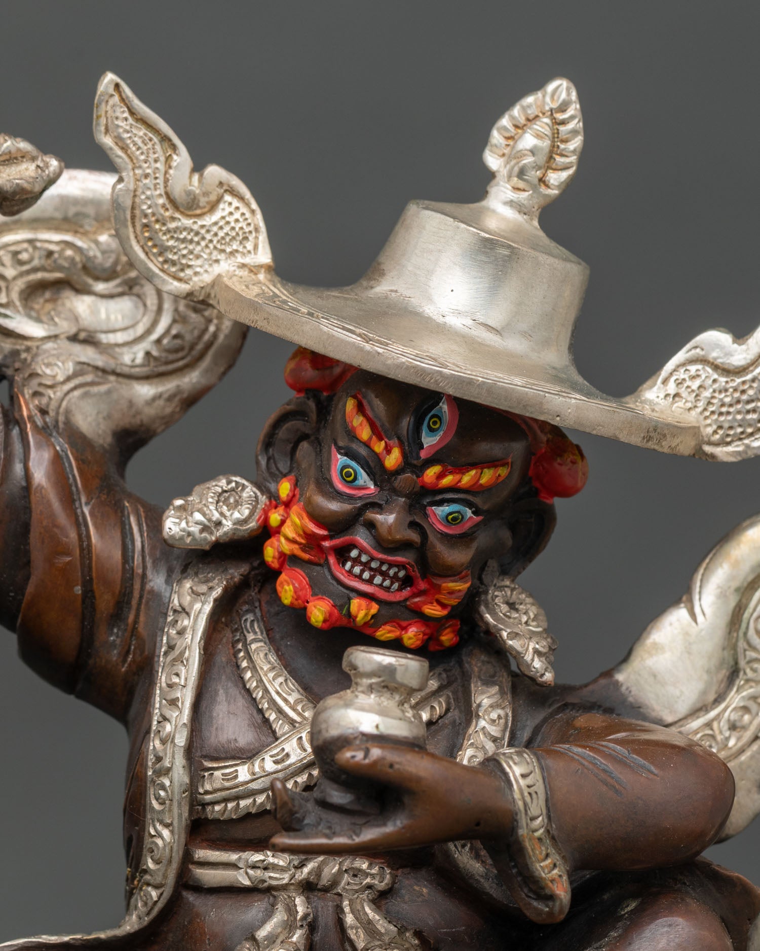 Close up Pehar Gyalpo face detail three headed wrathful protector deity Nyingma hat Buddhist art Himalayan craftsmanship sacred guardian expression