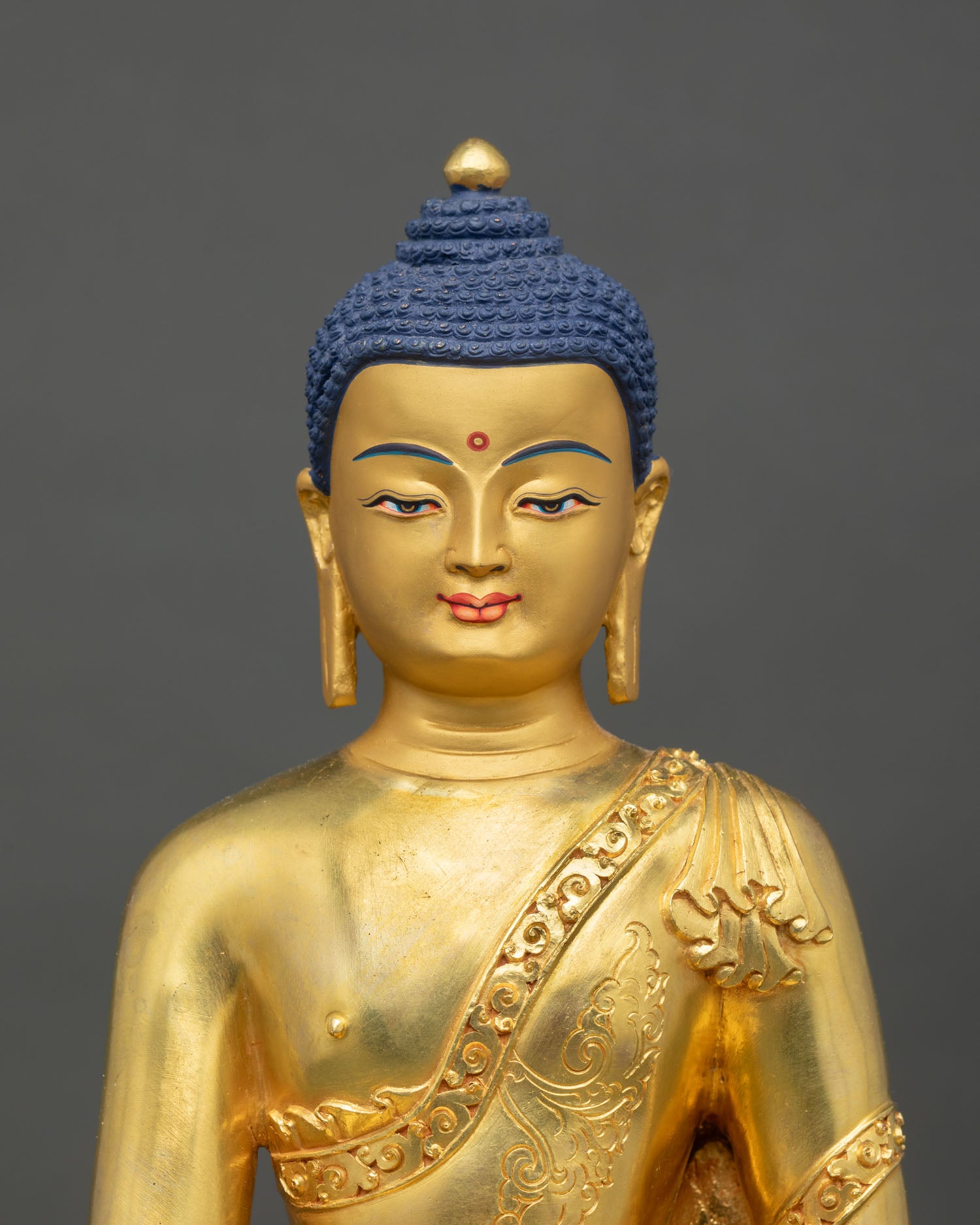 Close up Shakyamuni Buddha face detail gold painted serene expression Himalayan Newari craftsmanship Patan Buddhist sacred art