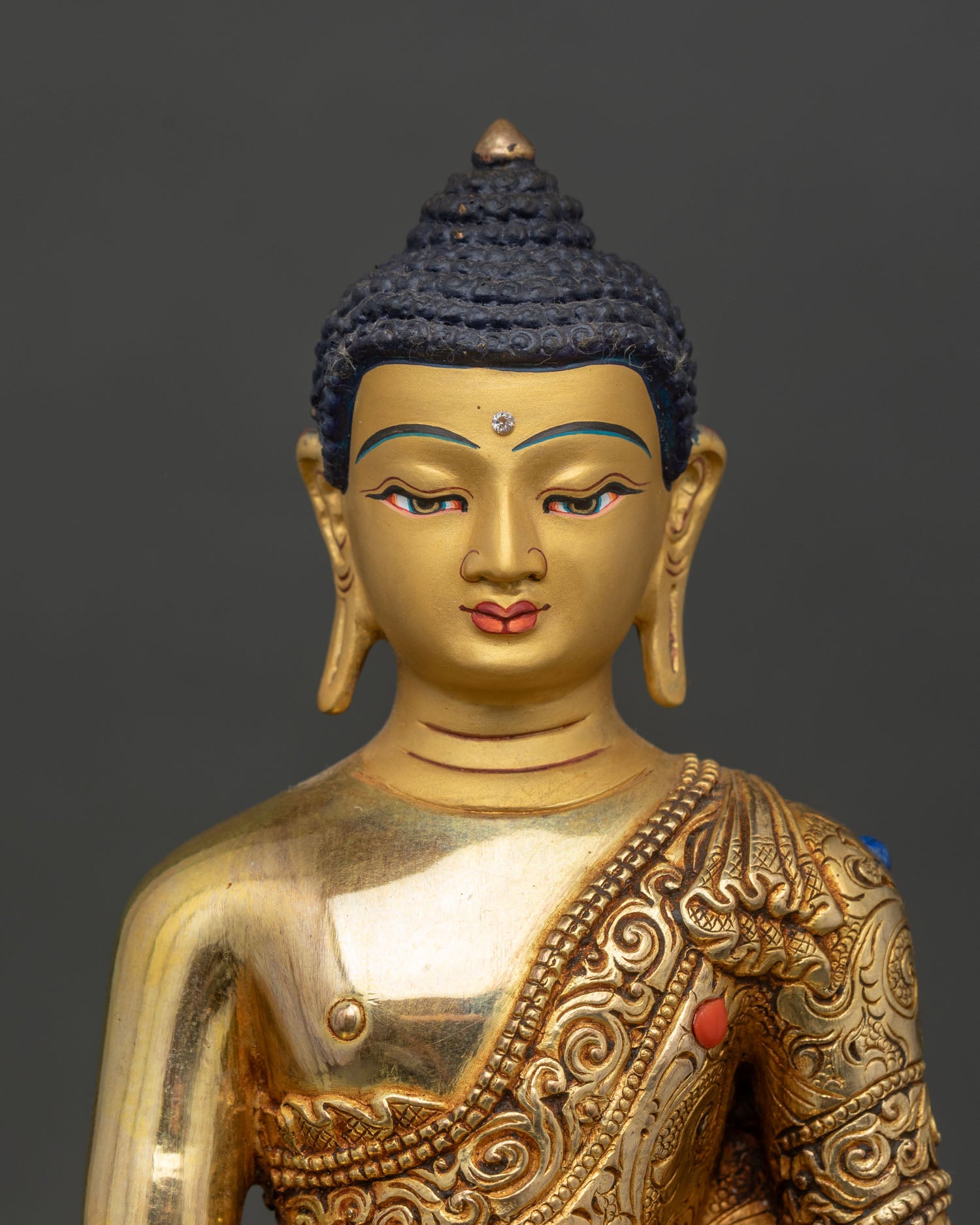 Close up Shakyamuni Buddha gold face turquoise coral stone inlays detailed craftsmanship Nepal