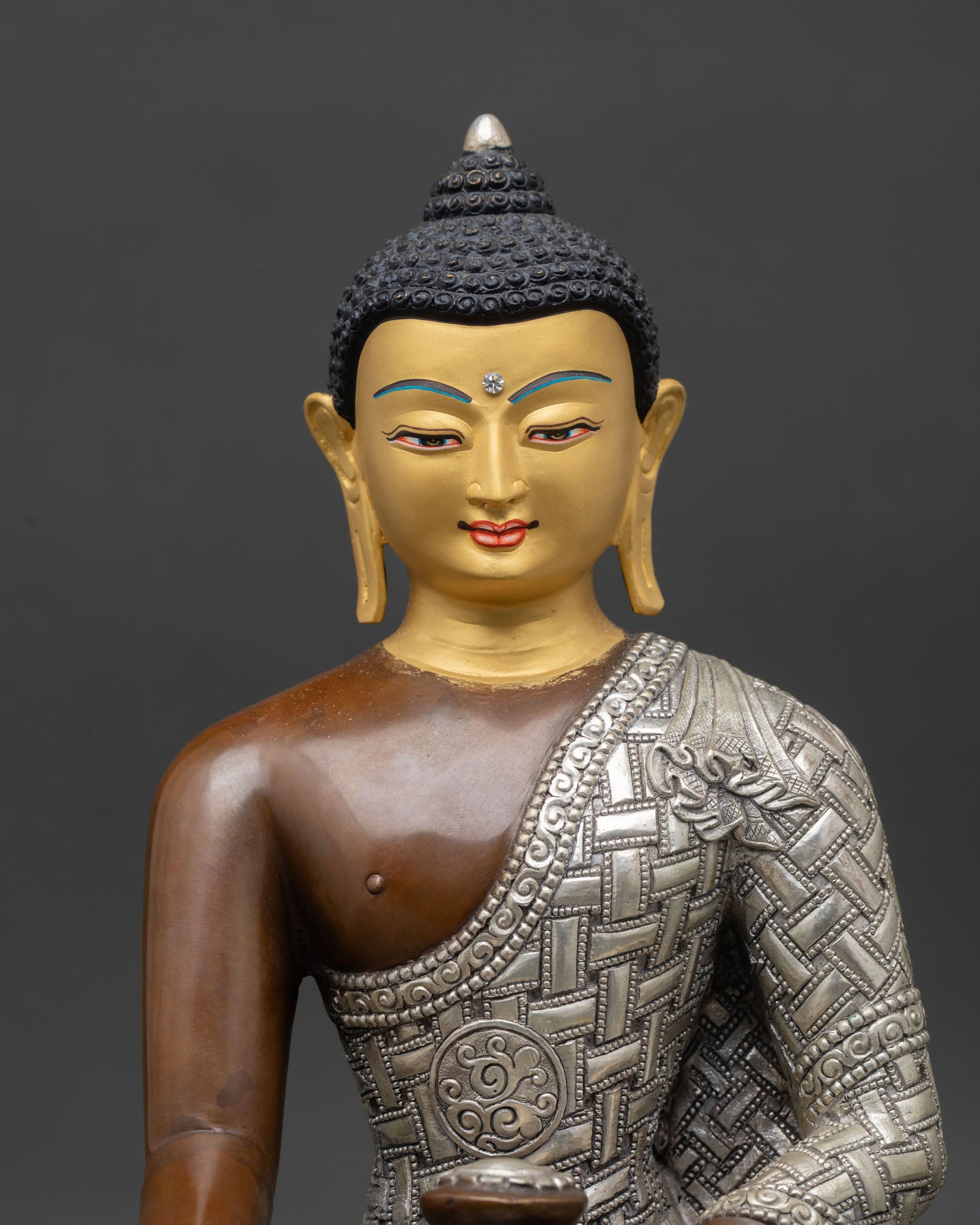 Close up Shakyamuni Buddha gold painted face peaceful expression handcrafted copper statue Nepal